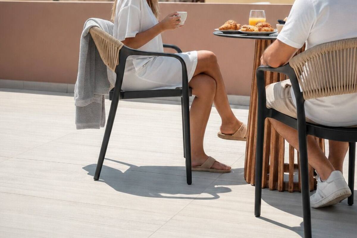 A couple dining on a terrace with a view of a bell tower and clock.