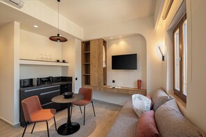 Suite Confort, vue ville | Coin séjour | TV connectée de 40 pouces avec chaînes par câble