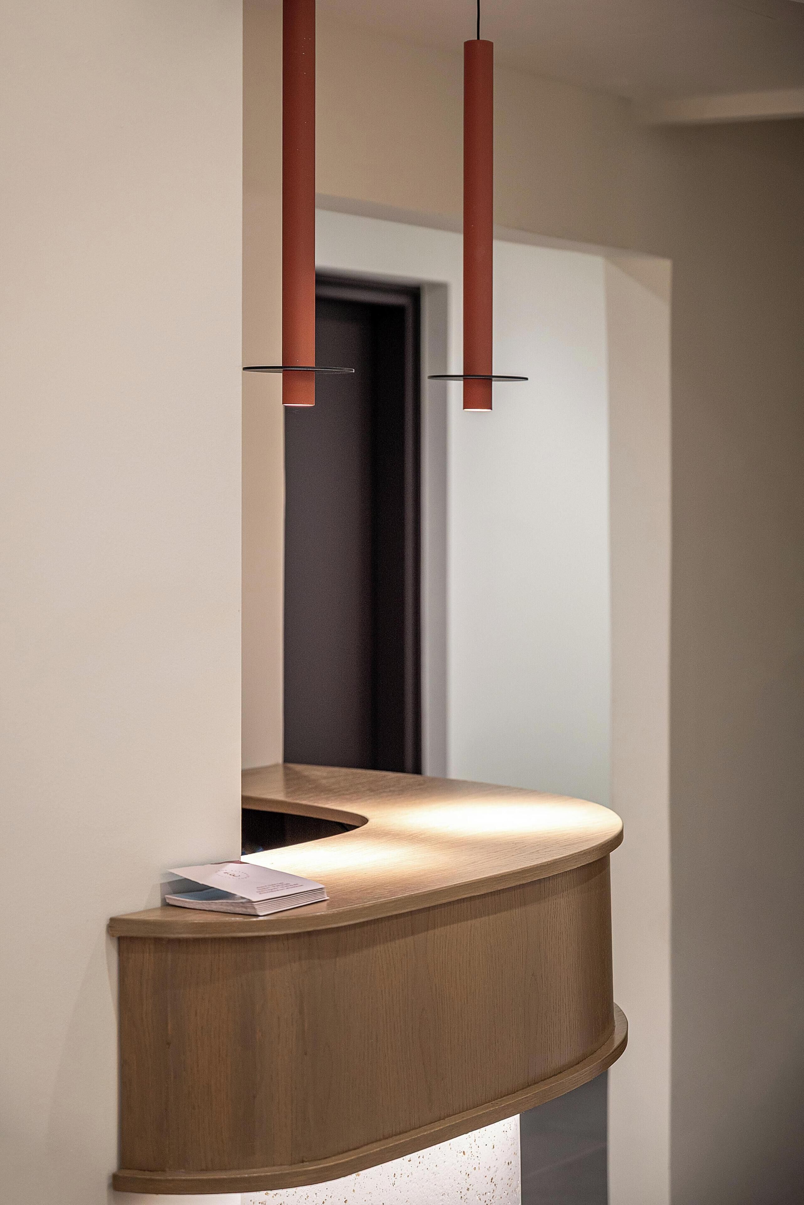 A reception desk with a wooden finish and a magazine on it.