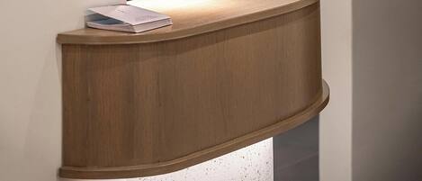 A reception desk with a wooden finish and a magazine on it.