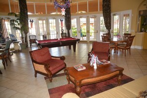 A spacious room with a pool table, comfortable seating, and large windows allowing natural light. - The Beauty of Solana Near Disney and Universal (Davenport)