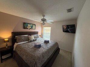 A bedroom with a bed, a ceiling fan, a television, and a window with blinds. - The Beauty of Solana Near Disney and Universal (Davenport)