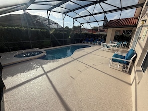 Una piscina cubierta al aire libre con sillas de descanso y un área de patio.