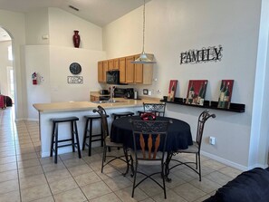 Una cocina moderna con una isla central, armarios de madera y un letrero que dice 'FAMILIA' en la pared.