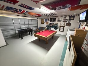 A room with a pool table, foosball table, and a large vehicle model. - The Beauty of Solana Near Disney and Universal (Davenport)