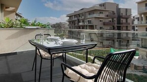 A balcony with a glass table and chairs, overlooking a residential area. - Kennah Studio | Villette Sodic, New Cairo (New Cairo)