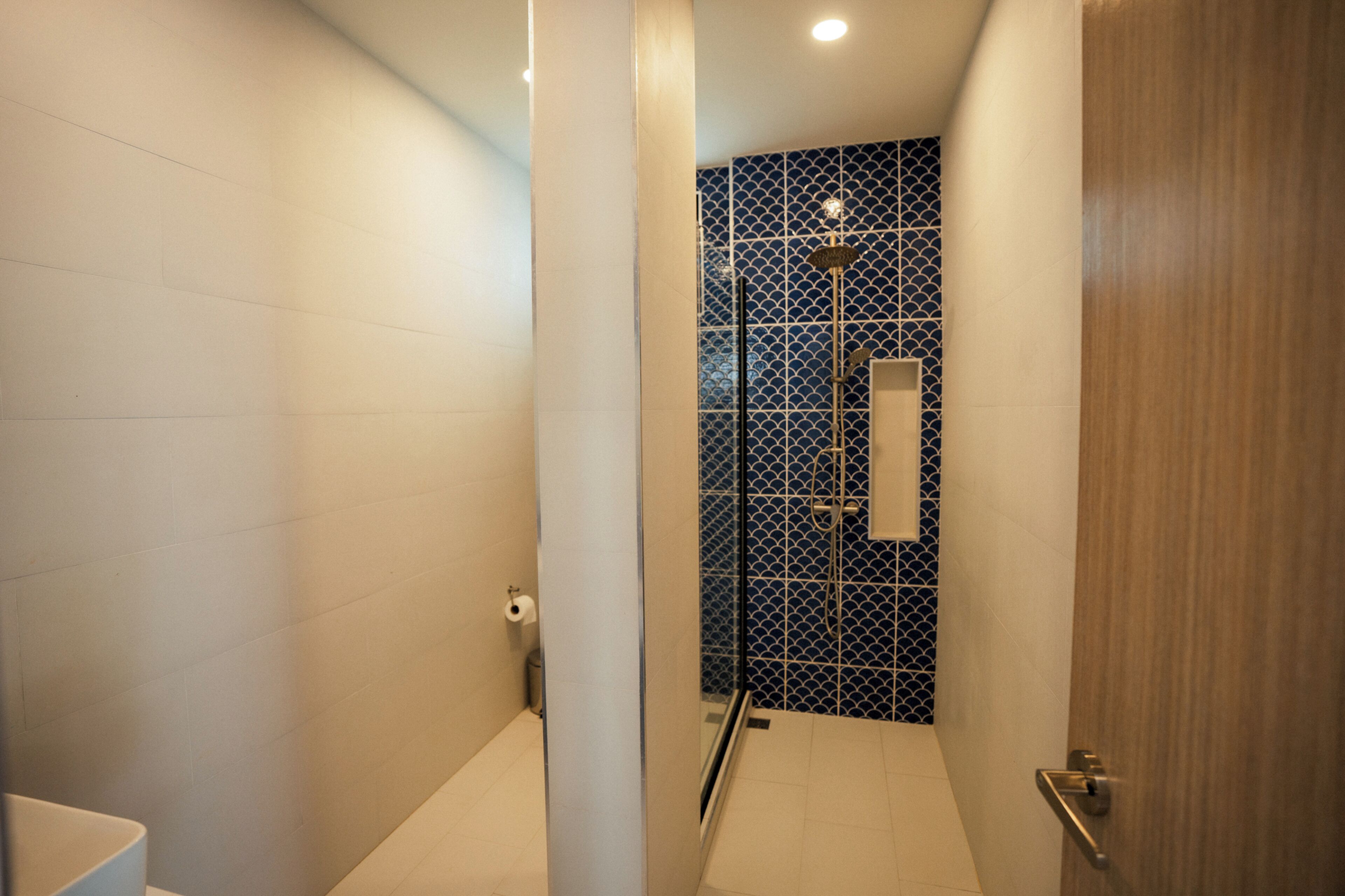 Un baño moderno con zona de ducha, inodoro y lavamanos.