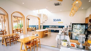 A modern cafe with wooden furniture, a central island, and a breakfast bar. - Seava Beach (Tha Sala)