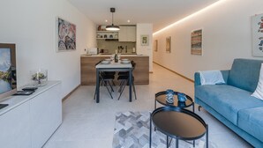 A modern apartment with a dining area, kitchen, and living room.