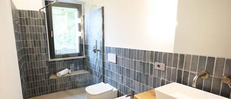 Ein Badezimmer mit Dusche, Toilette und Waschbecken.