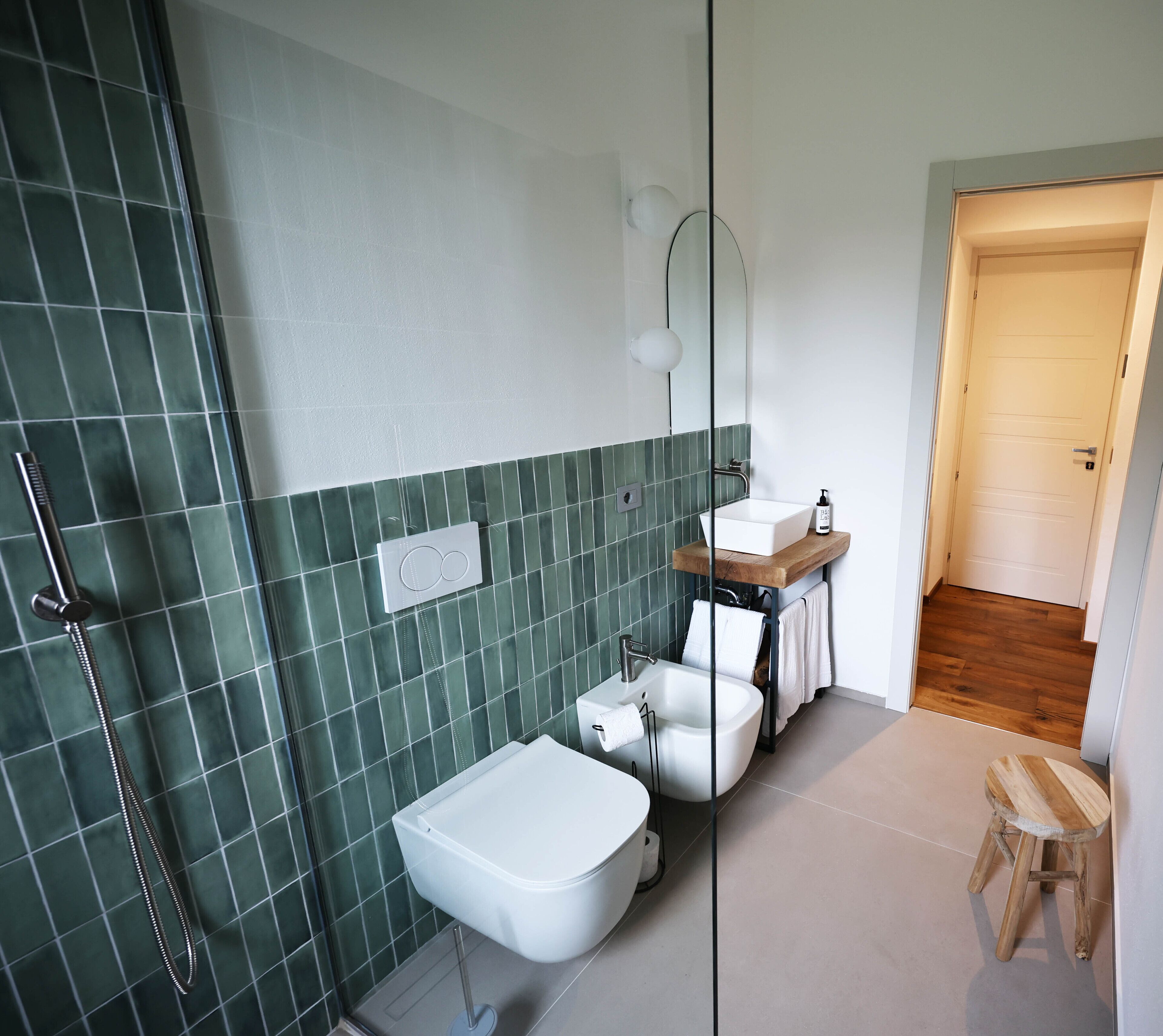 A modern bathroom with a shower, toilet, and sink.