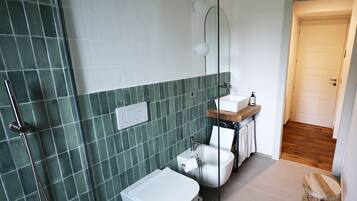 A modern bathroom with a shower, toilet, and sink.