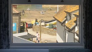 Ein Zimmer mit großem Fenster und Blick auf Strand und Gebäude.