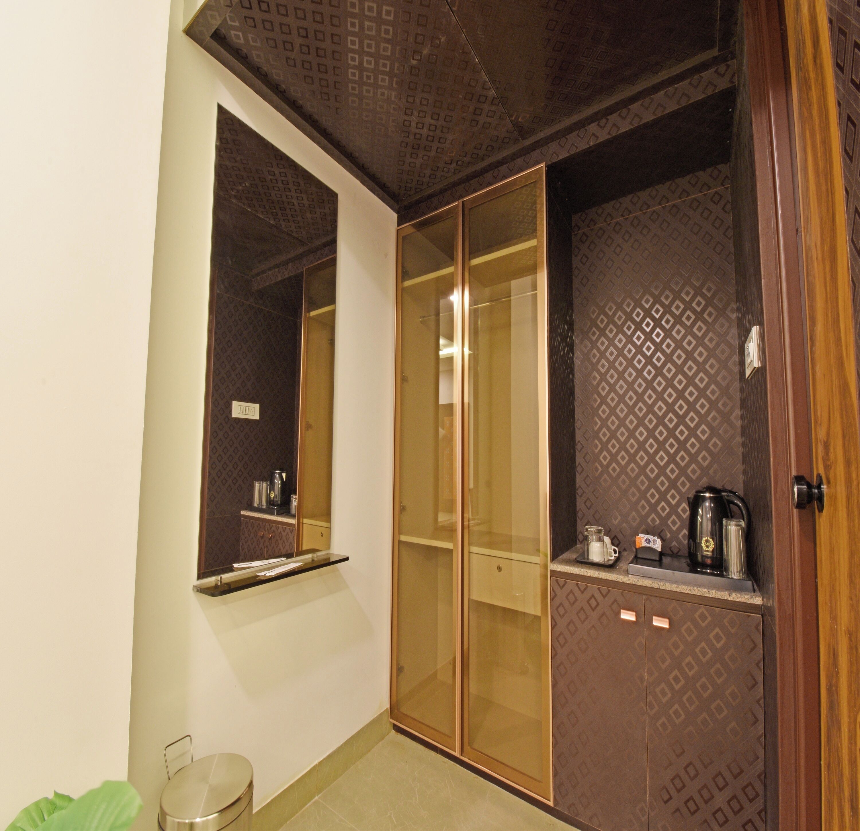 A bathroom with a mirror, a toilet, a sink, and a cabinet with a coffee maker.