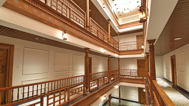 A multi-level interior with wooden railings and a patterned floor. - A K G Hotel (Puducherry)