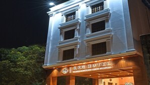 A hotel with a classic architectural design, featuring a prominent entrance and illuminated signage. - A K G Hotel (Puducherry)