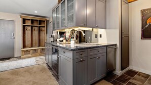 A kitchen with grey cabinets, a granite countertop, and a built-in oven.