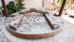 A rustic outdoor seating area with a stone table and metal bench. - Callejón del Pozo I. (Gálvez)