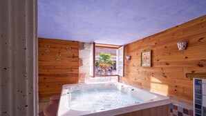 A wooden interior with a hot tub, wooden walls, and a view through an open door. - Périgord Romantique, Guest Rooms 'Le Pré Fleuri' with Pool in the Heart of Ribéracois (Saint-Sulpice-de-Roumagnac)