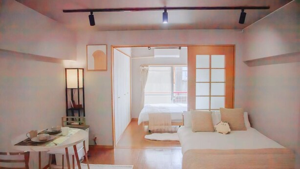 Un dormitorio con cama, mesita de noche y escritorio con sillas.