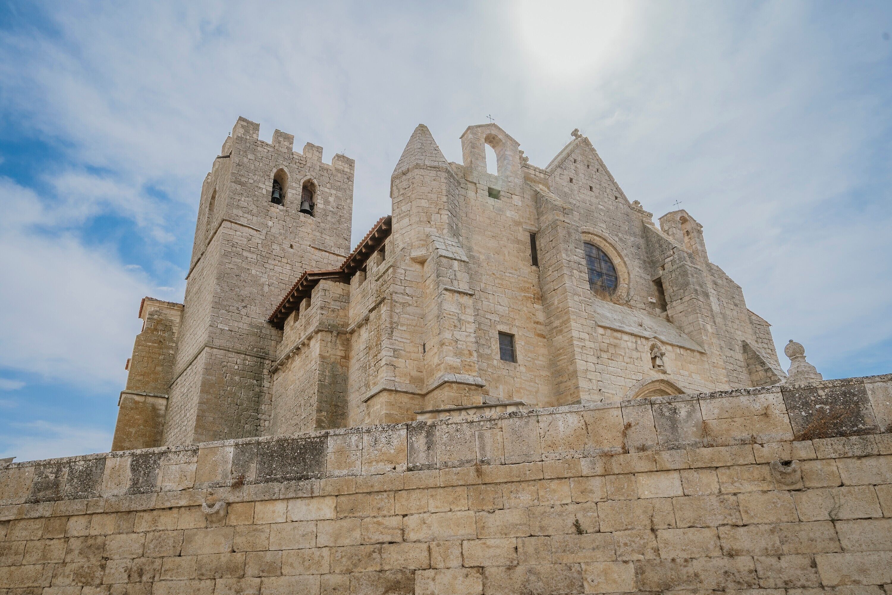 A historic stone castle with multiple towers and a large arched window.