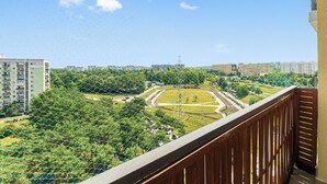 A balcony with a view of a park, residential buildings, and a railway track. - RentPlanet - Apartament Przymorze (Gdańsk)