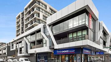 Un edificio moderno con una tienda de licores 'First Choice Liquor' en la planta baja.