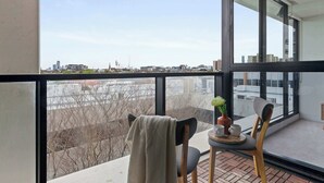Ein Balkon mit Tisch, Stühlen und einem Blumentopf.