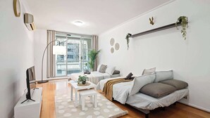 A modern living room with a sofa, a coffee table, and a TV stand. - A Stylish Studio for 6, Next to Darling Harbour (Sydney)
