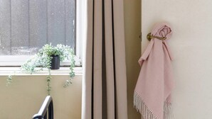 A room with a bed, a window with curtains, a potted plant, and a wall-mounted towel rack. - A Comfy & Cozy Apt in Clifton Hill, Free Parking (Melbourne)
