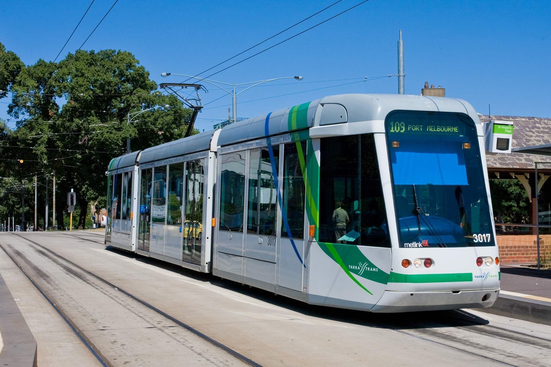 A modern tram with destination signage, traveling on a tram track.