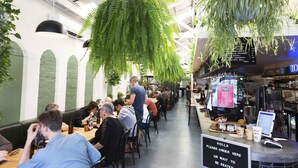 Ein Restaurant mit Innenbereich, einer Speisekarte und hängenden Pflanzen.