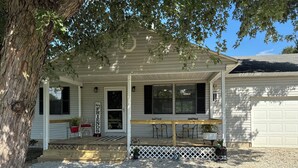 A white house with a porch, a wooden bench, and a sign that reads "by FRIENDS". - Hey friends, welcome to Maggie’s Place to relax and enjoy some peace and quiet  (Rogersville)