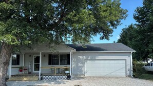 A single-story house with a covered porch, a garage, and a gravel driveway. - Hey friends, welcome to Maggie’s Place to relax and enjoy some peace and quiet  (Rogersville)