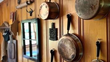 A kitchen with wooden paneling and hanging pots.