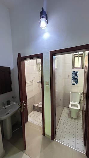 Een badkamer met toilet, bidet en wastafel.