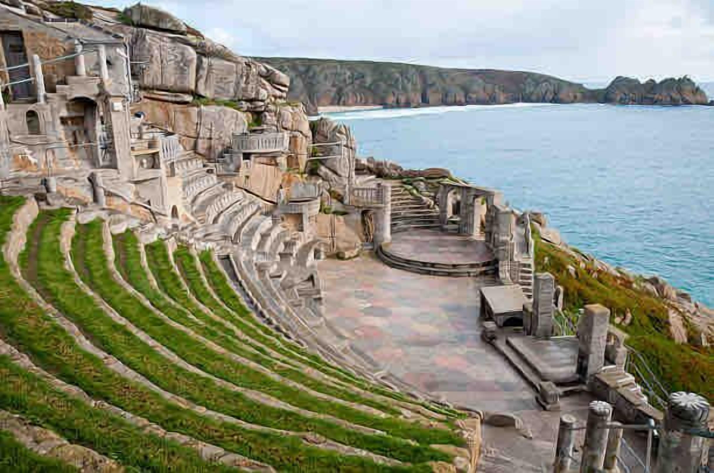 An amphitheater with tiered seating and a stage, overlooking a coastal area.