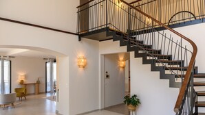 Ein modernes Interieur mit Treppe, Essbereich und Wohnbereich.