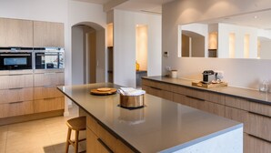 Eine moderne Küche mit Holzausbau, einer großen Kochinsel und eingebauten Geräten.