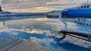A waterfront pool with a clear view of the sky and clouds reflected in the water. - Breathtaking views on historical street- central (Penzance)