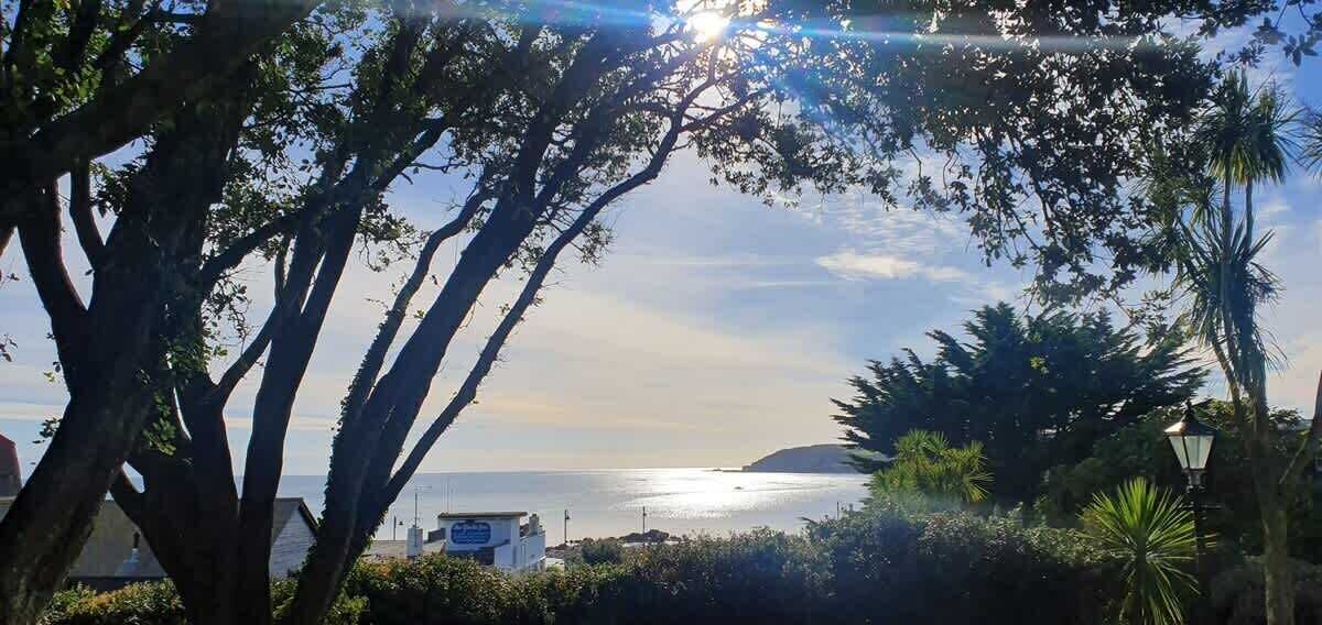 A coastal view with trees and a building in the foreground.