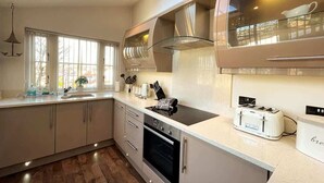 A modern kitchen with a built-in oven, a stovetop, and a toaster.