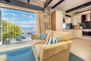 A living room with a sofa and a view of the outside. - Harbourside apartment with seaviews and parking (Penzance)