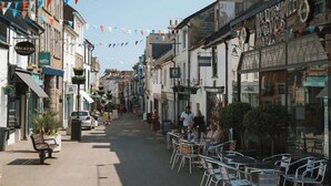 Une rue bordée de boutiques et dotée d’espaces de terrasses.