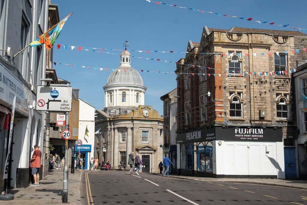 A street with historic buildings, a dome, and a Fujifilm photo print services shop.