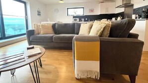 Una sala moderna con un sofá, una mesa de centro y vistas al exterior.