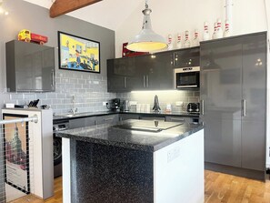 A modern kitchen with a granite countertop, stainless steel appliances, and a large island. - Stylish~Tasteful~2Bed~2Bath~Central~Townhouse (Penzance)