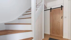 A staircase with wooden steps leading to a room with a sliding door. - The Coach House, Penzance- Cosy Nook for 2 (Penzance)
