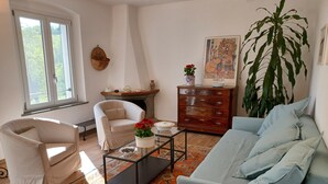Una sala de estar con sofá, sillón, mesa de centro y chimenea.