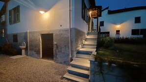 Una casa moderna con fachada de piedra, una puerta principal y una escalera que lleva a la entrada.